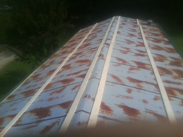 Rusted metal roof panels with new wood purlins before replacement — Storm Damage Roof Repair in Menasha by Roofing Brothers