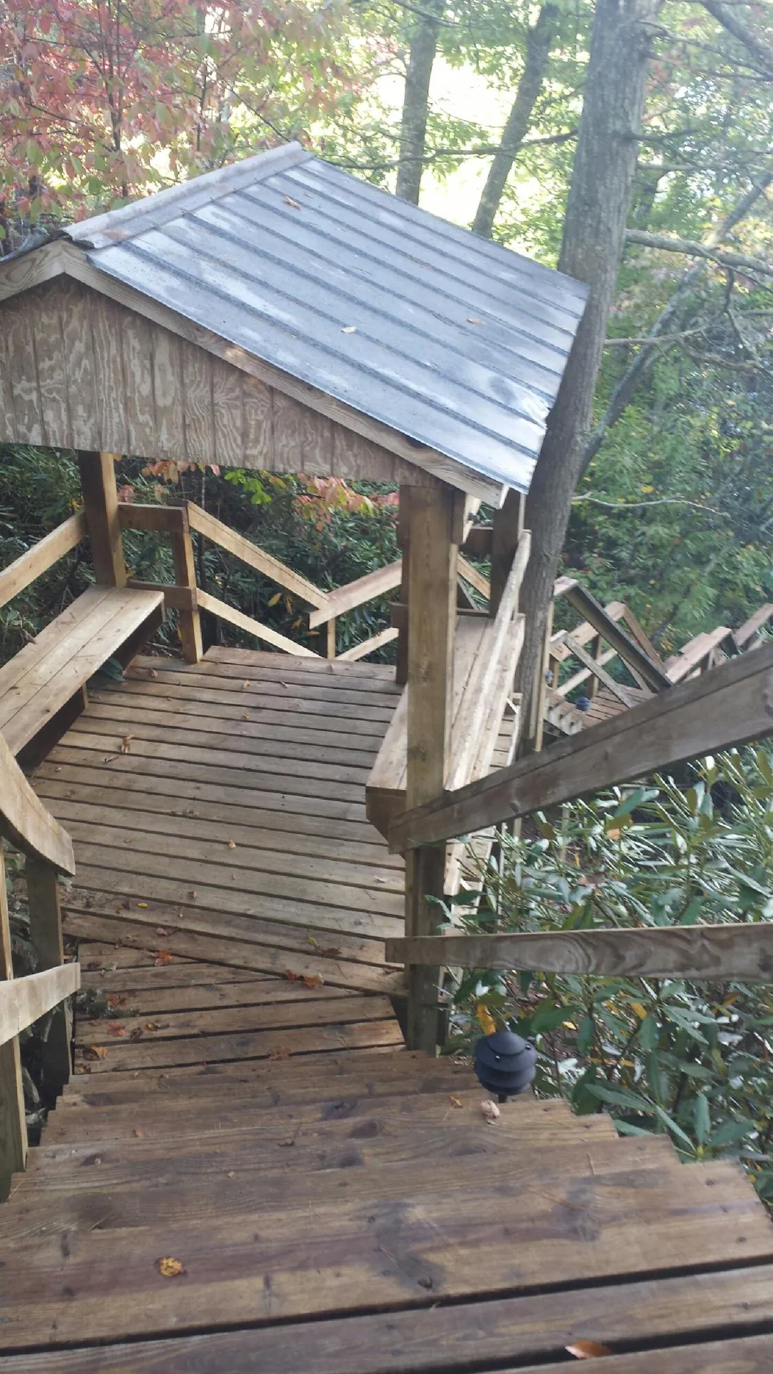 Metal roofed shelter over wooden steps on a wooded walkway — Skylight Repair & Installation work by our crew in Menasha