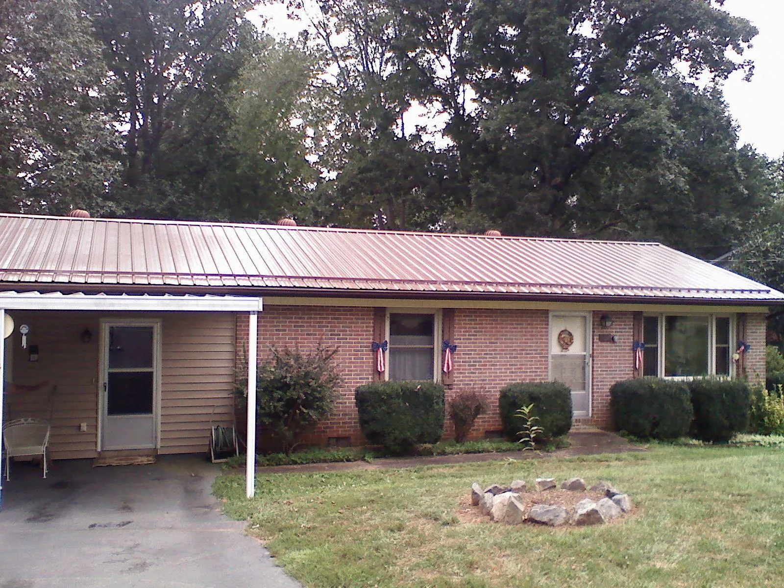 Bronze metal roof and carport on a brick ranch home — Roof Repair work by our crew in Menasha