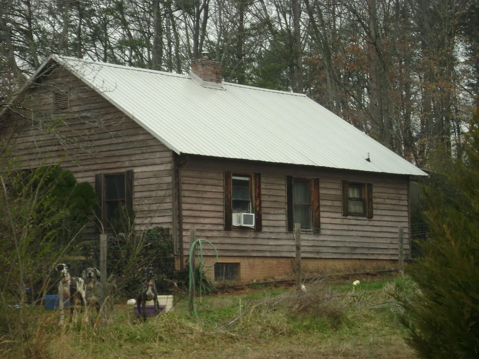 White metal roof on an old wood sided farmhouse, from a Metal Roof Installation job in Menasha